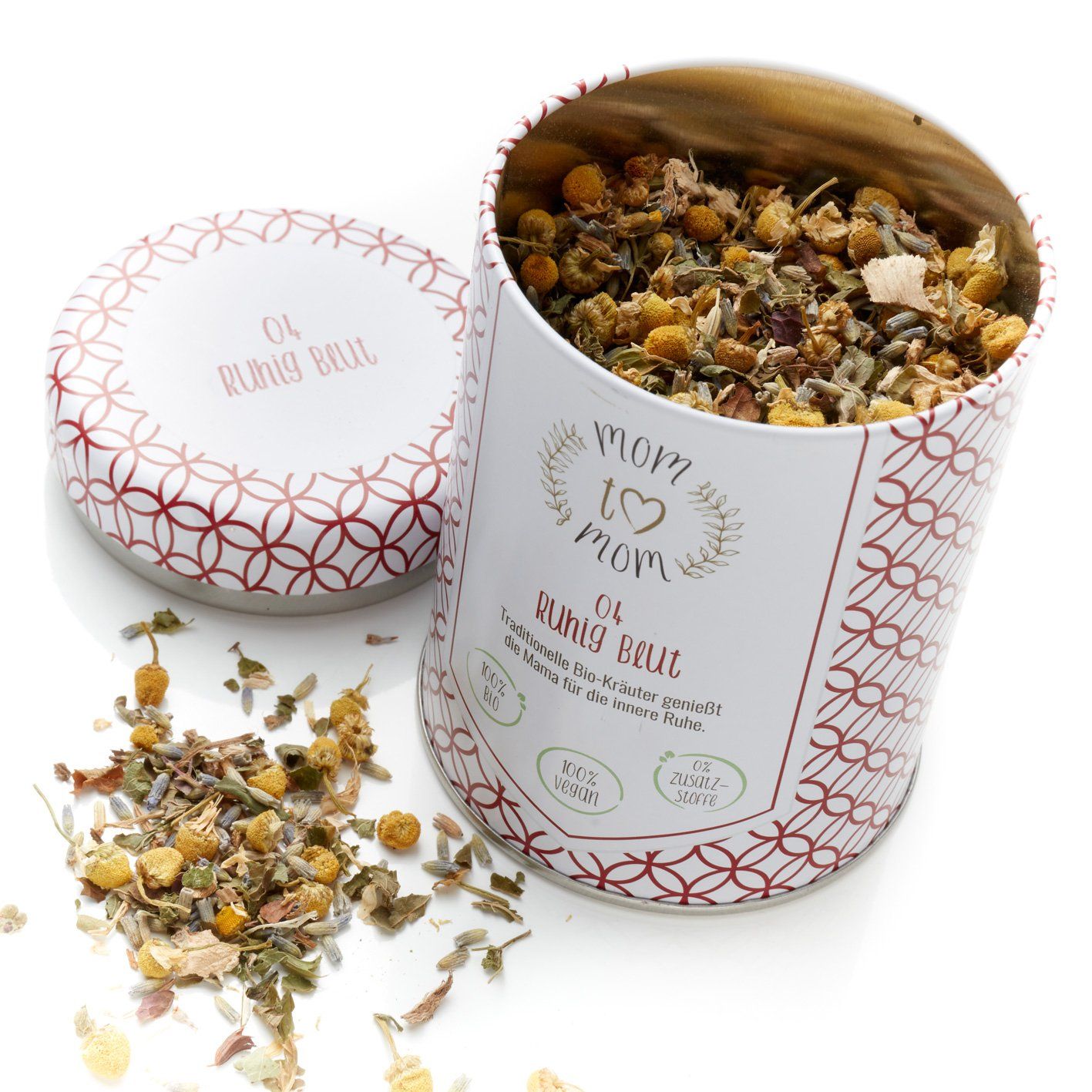 Runde Dose mit Deckel, gefüllt mit Kräutern. Aufschrift: mom to mom, Ruhig Blut. Roter Muster-Dekor.