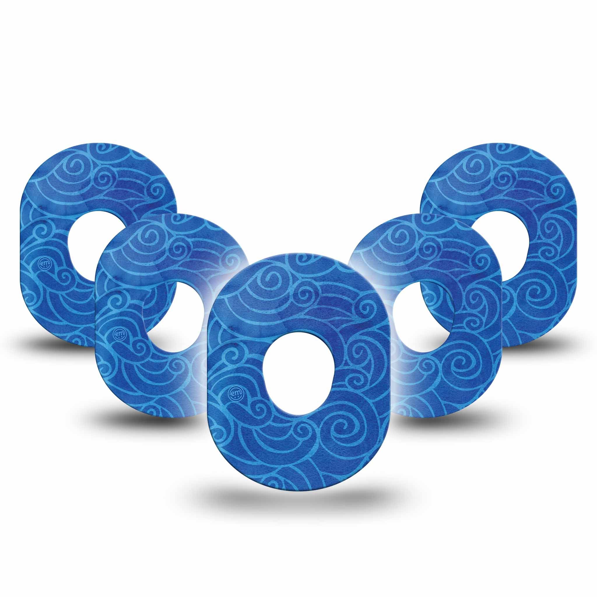 Fünf blaue, ringförmige Pflaster mit Wirbelmuster. Mittig Loch. Schattenwurf.