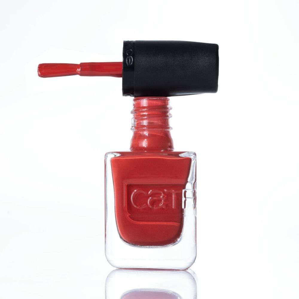Roter Nagellack in einem durchsichtigen Fläschchen mit schwarzem Deckel und Pinsel.