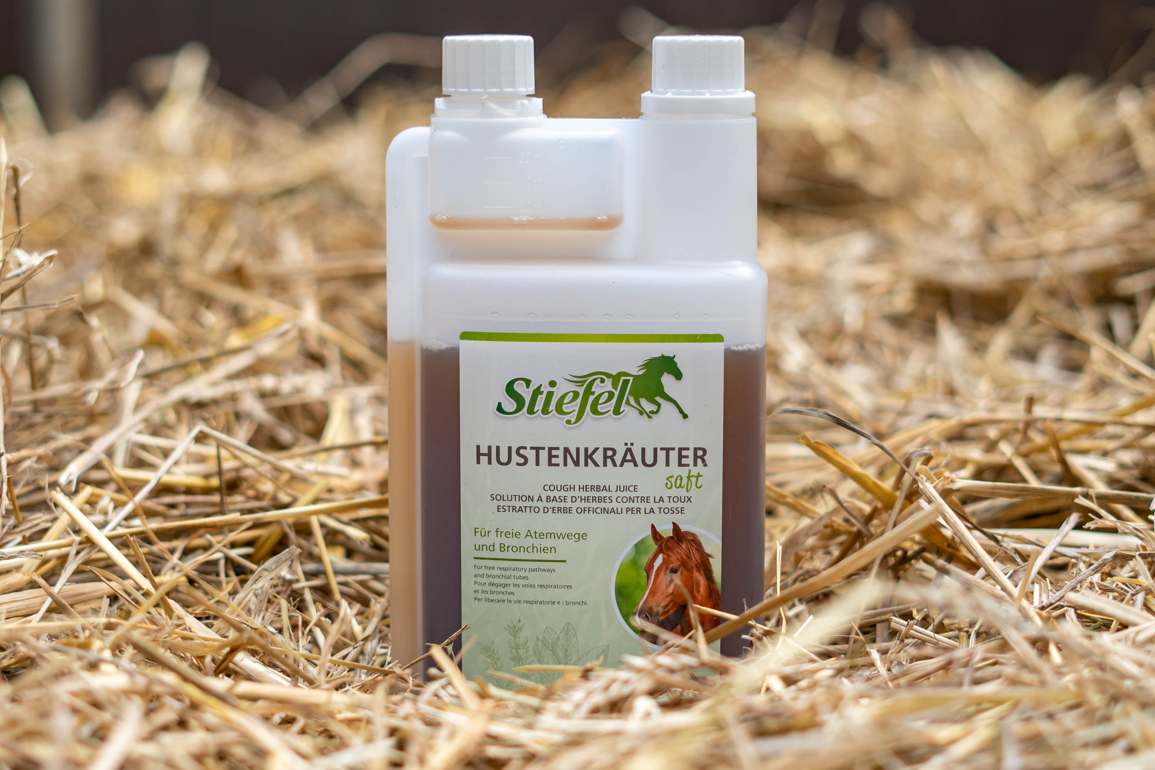 Flasche mit brauner Flüssigkeit, weißem Deckel und Etikett. Auf dem Etikett steht der Produktname und ein Pferd. Hintergrund: Stroh.
