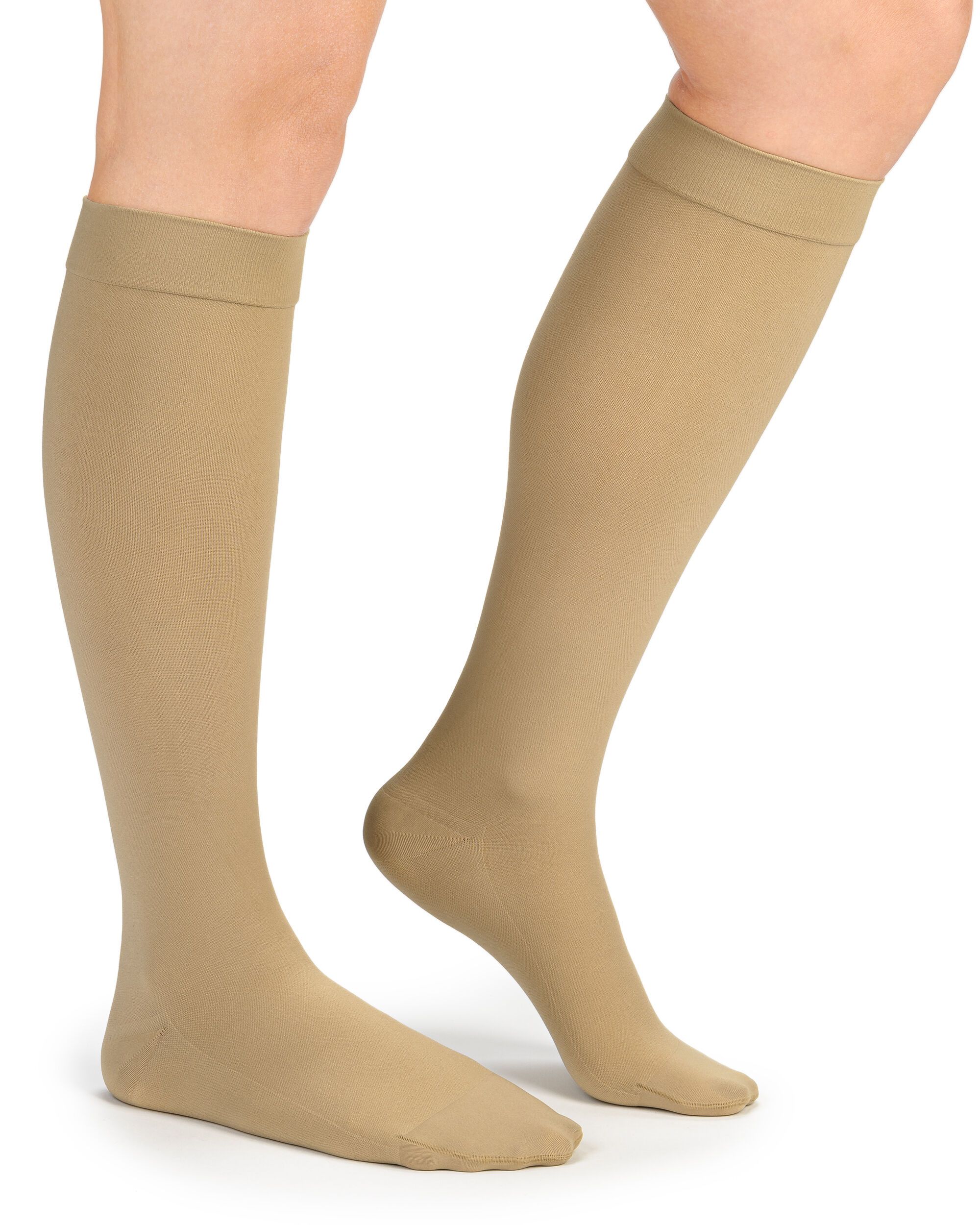 Beige Kompressions-Kniestrümpfe an Beinen. Strümpfe reichen bis unterhalb des Knies. Offene Fußspitze.