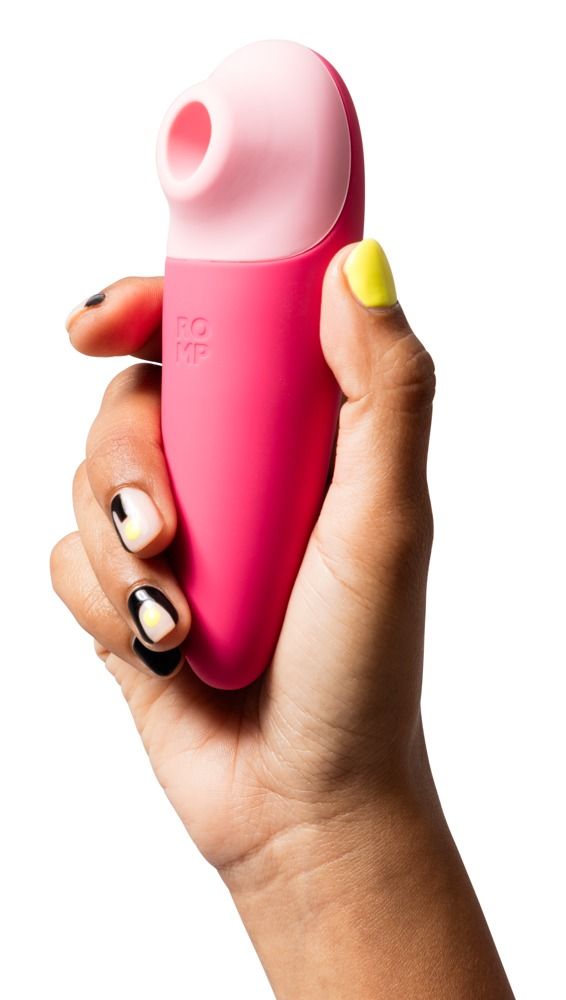 Rosa Vibrator in einer Hand gehalten. Der Kopf ist rosa. Auf dem Produkt steht ROMP.
