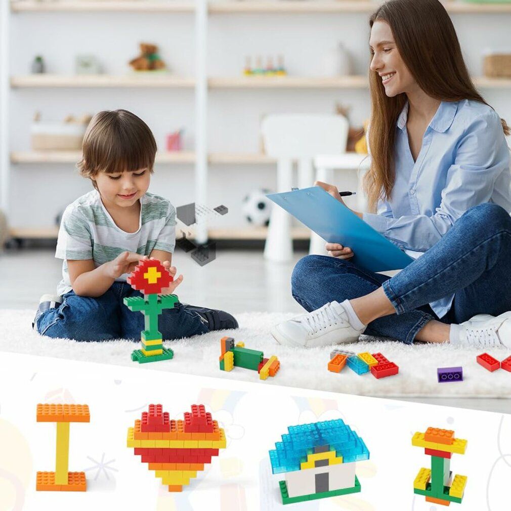 Ein Kind spielt mit bunten Bausteinen, eine Frau schaut zu. Verschiedene Baustein-Modelle sind im Vordergrund zu sehen.