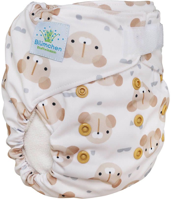 Weiße Stoffwindel mit Teddybären-Muster. Klettverschluss, Druckknöpfe und das Label "Blümchen Stoffwindeln" sind sichtbar.