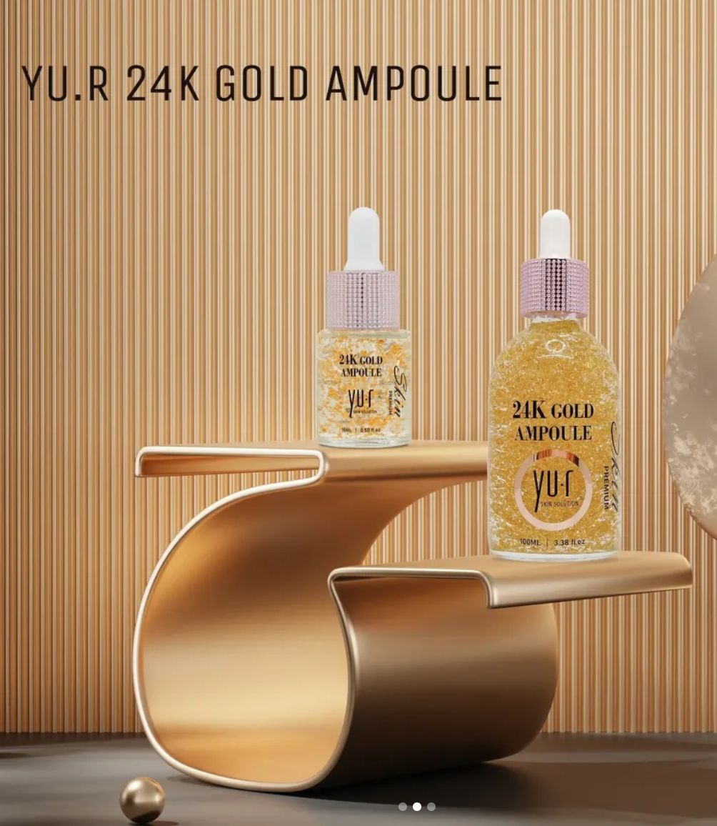 Zwei Serumflaschen mit Goldflocken auf goldfarbener Präsentationsfläche. Aufschrift: 24K Gold Ampoule, Yu.R.