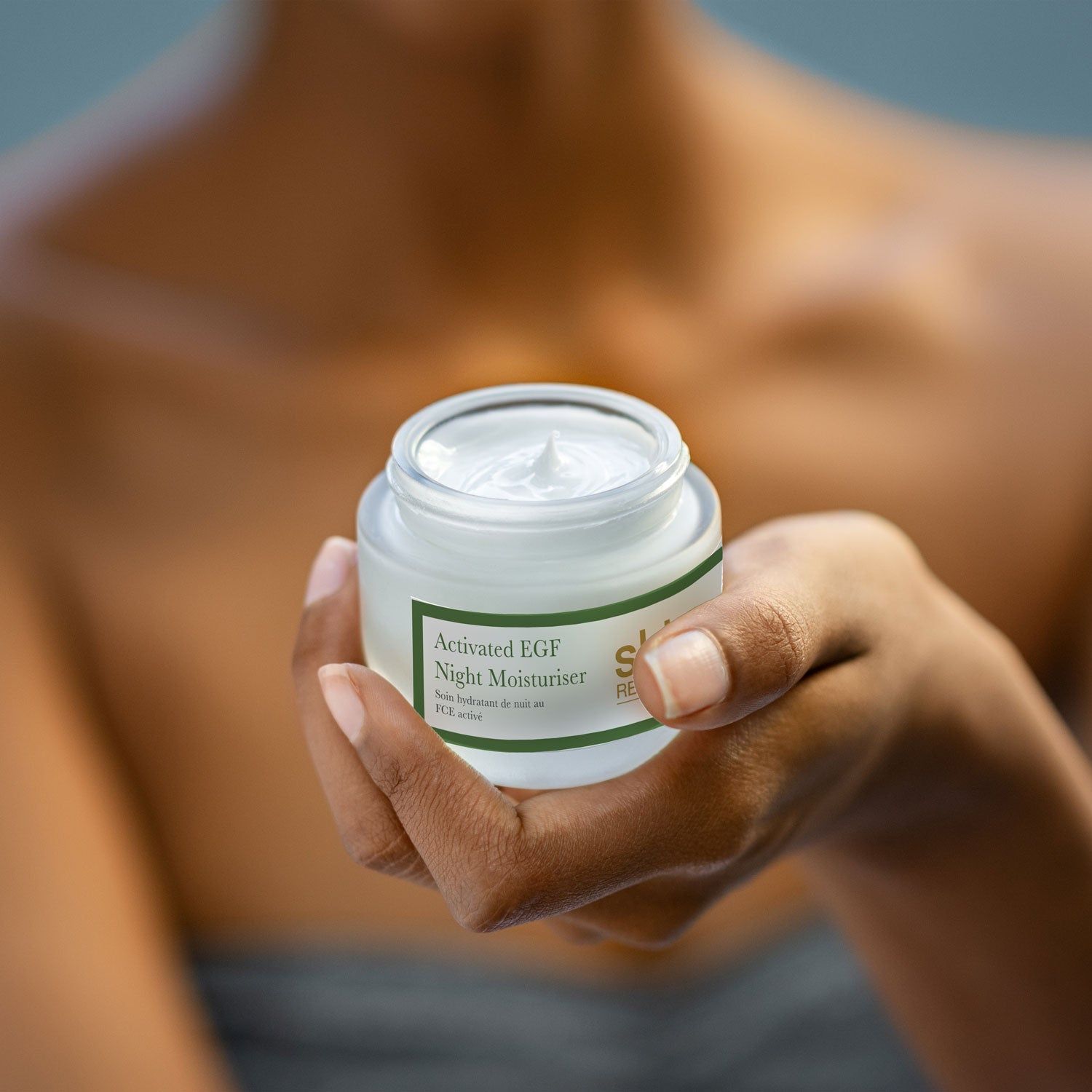 Person hält einen Tiegel. Aufschrift: Activated EGF Night Moisturiser, Skin Research.