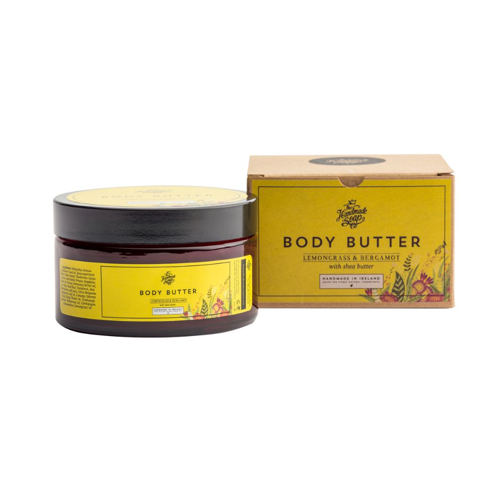 Braune Dose und Karton mit gelben Etiketten. Aufschrift: Body Butter, Zitronengras & Bergamotte. Handmade in Ireland.