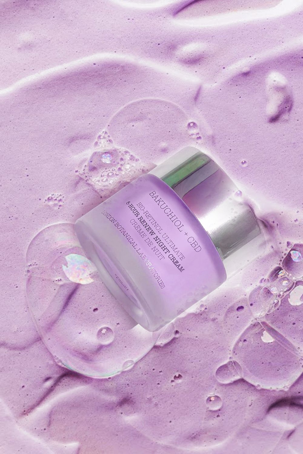 Creme-Tiegel mit silbernem Deckel, teilweise in lila Schaum getaucht. Aufschrift: Bakuchiol + CBD, Bio-Retinol Ultimate, 8-Hour Renew Night Cream, London Botanical Laboratories.