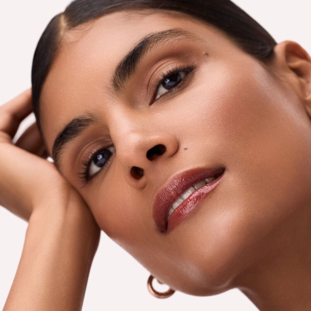 Porträt einer Frau mit Lippen-Make-up. Die Lippen sind mit einem glänzenden Farbton bemalt.