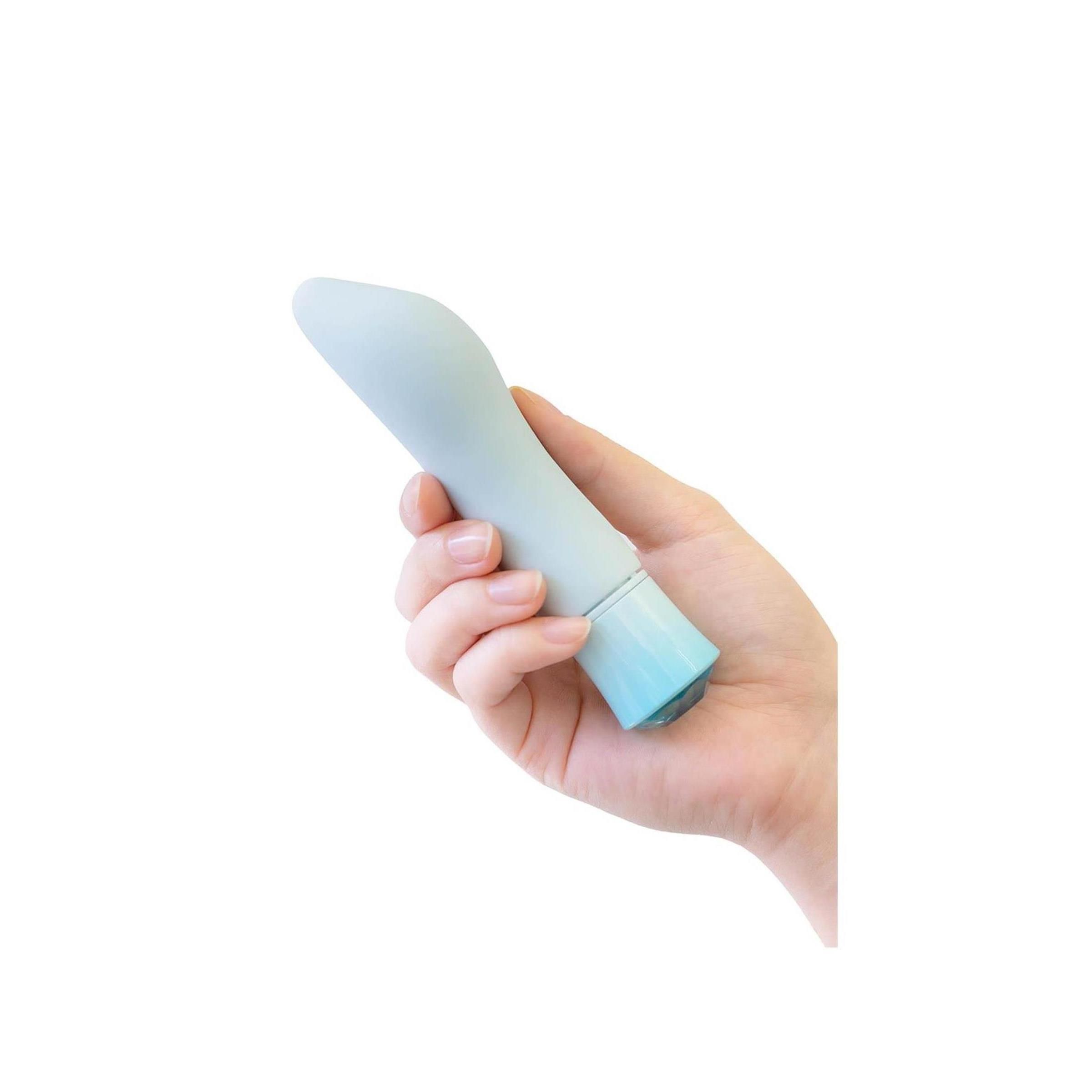 Hellblaues Wellness-Produkt in einer Hand gehalten. Das Produkt hat ein Kristall-Design am Ende.