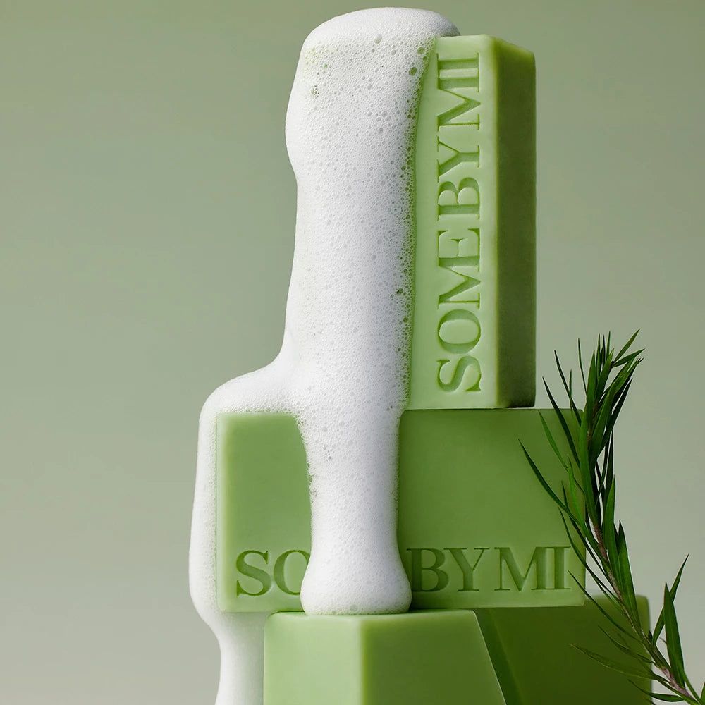 Gestapelte grüne Seifenstücke mit Schaum. SOMEBYMI ist auf den Seifen zu sehen.