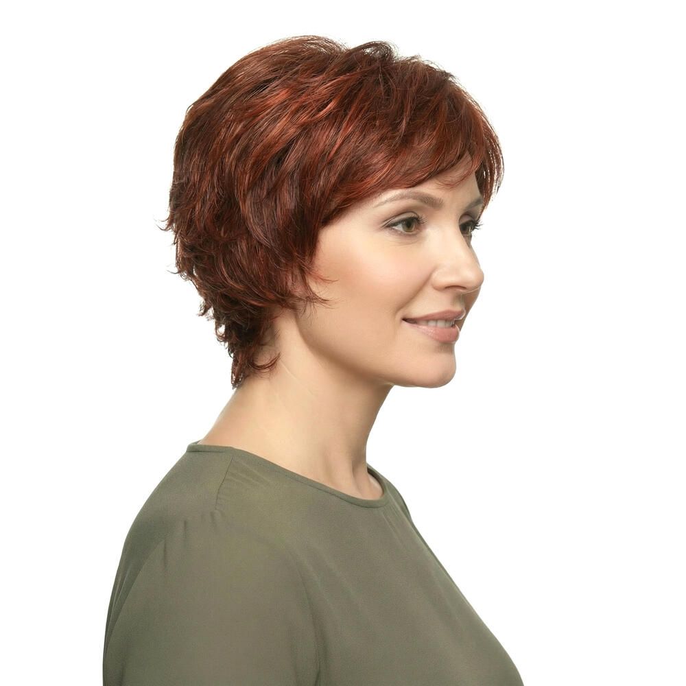 Frau mit roter Perücke. Kurzer, gewellter Haarschnitt. Seitenansicht, lächelnd.