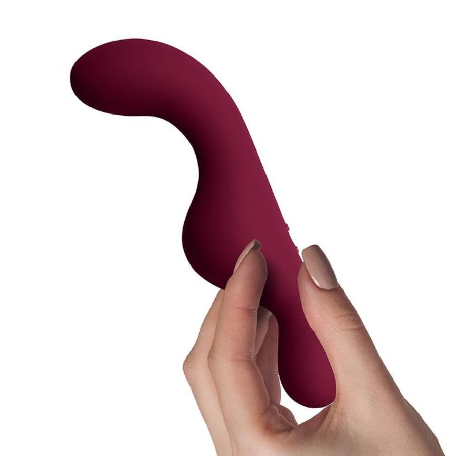 Bordeauxfarbenes Wellness-Produkt, gebogen, in einer Hand gehalten. Glänzende Oberfläche, ergonomisches Design.