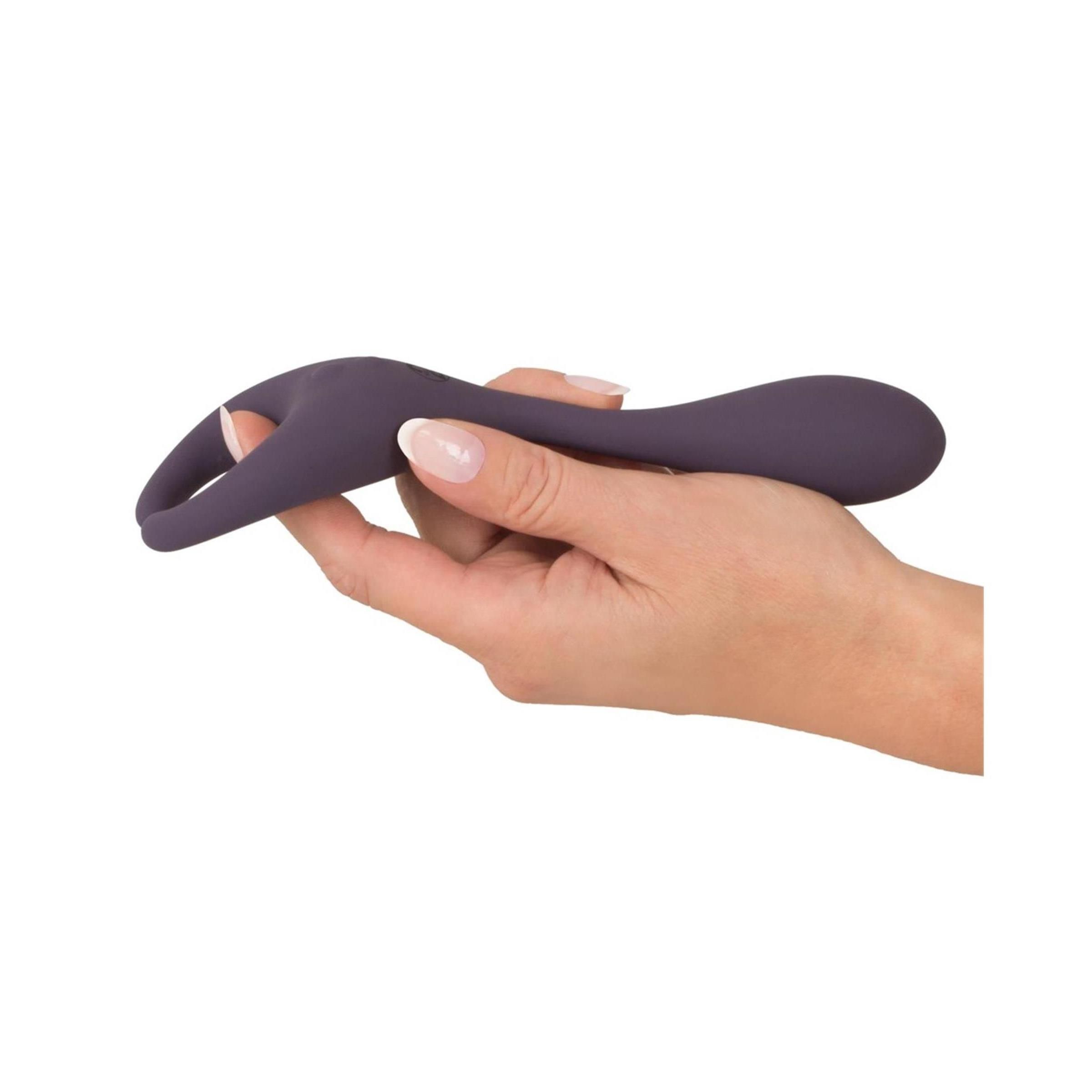 Hand hält lila Vibrator. Geschwungene Form. Glatte Oberfläche. Ringförmiger Teil.
