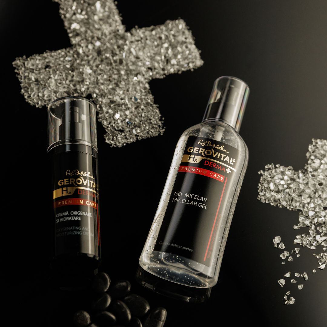 Zwei Flaschen, eine schwarz, eine transparent, neben einer Glas-Kreuz-Dekoration und Steinen. Aufschrift: Gerovital H3 Derma+ Premium Care.