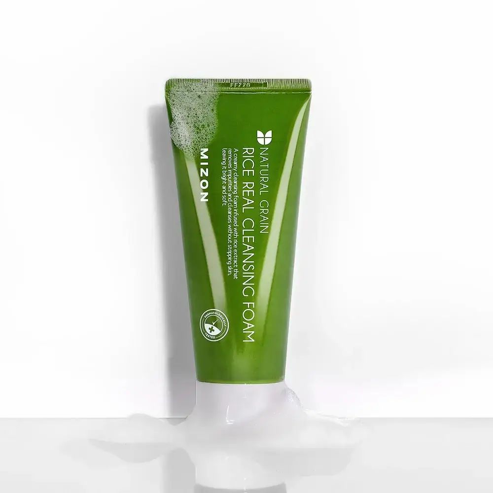 Grüne Tube mit weißem Verschluss. Schaum um die Tube. Aufschrift: MIZON Rice Real Cleansing Foam. Produktname und Logo.
