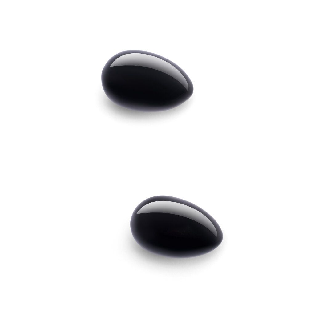 Zwei schwarze, ovale Obsidian-Eier. Glatte, glänzende Oberfläche.