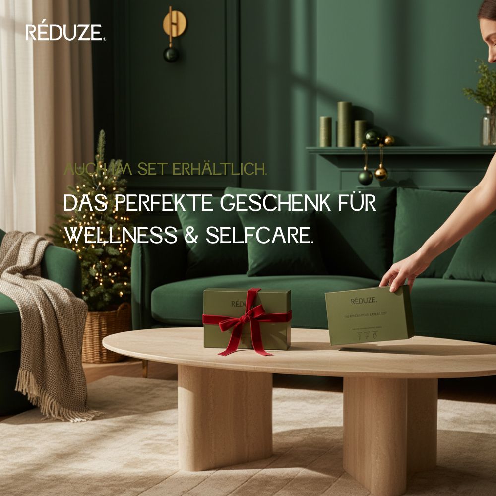 Geschenkbox mit Schleife auf einem Tisch. Text: RÉDUZE. Grün, Geschenk für Wellness.