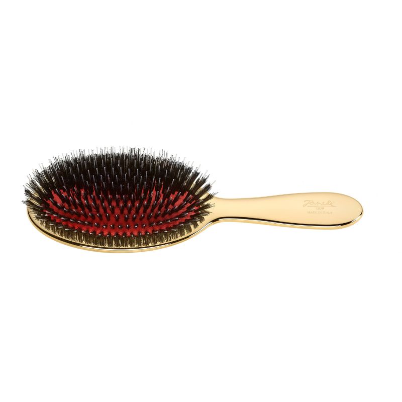 Goldfarbene Haarbürste mit ovalem Bürstenkopf und Griff. Schwarze und rote Borsten. Marke Janeke.