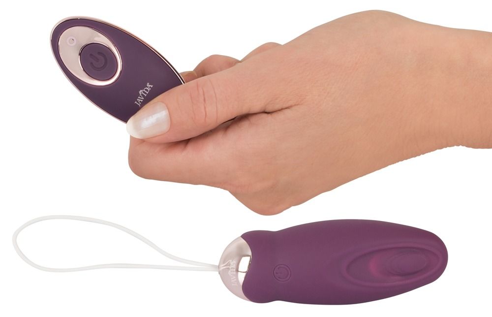 Hand hält Fernbedienung und Vibrationsgerät mit weißer Schlaufe. Auf weißem Hintergrund.