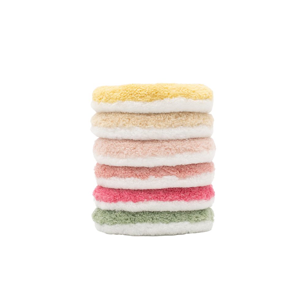 Sechs farbige Abschminkpads, gestapelt. Farben: gelb, beige, rosa, rot, grün. Flauschige Textur.
