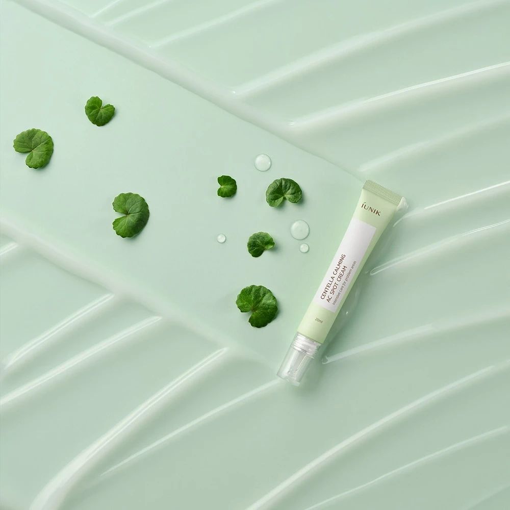 Grüne Tube auf grünem Untergrund mit Blättern und Wassertropfen. Produktname sichtbar.