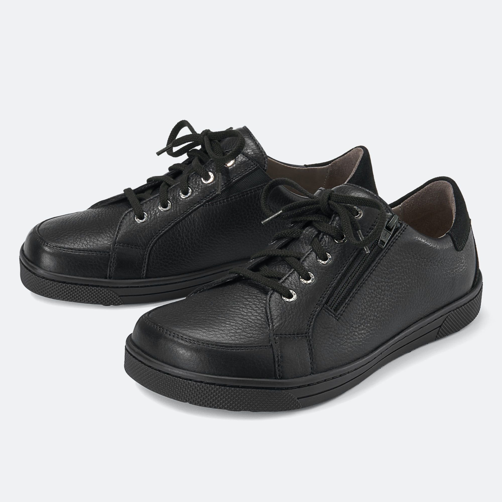 Schwarze Herren-Schnürschuhe mit breiter Passform. Beide Schuhe sind aus Leder und haben Schnürsenkel. Ein Schuh hat einen Reißverschluss.