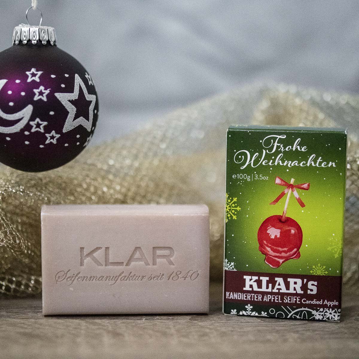 Seife und Verpackung. Seife mit Klar-Schriftzug. Verpackung mit Apfel-Illustration und "Frohe Weihnachten!".