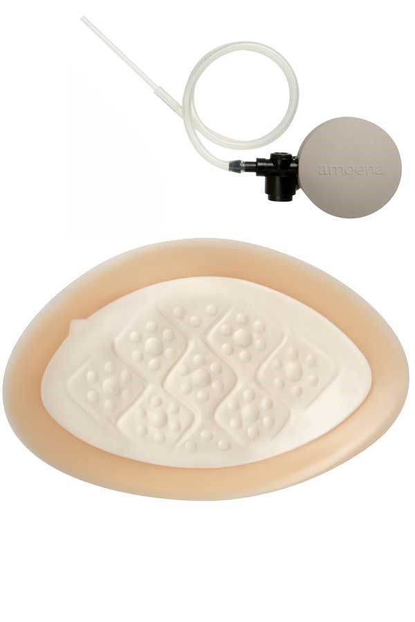 Brustprothese mit Pumpe. Elfenbein, mit strukturiertem Bereich. Pumpe mit Schlauch.