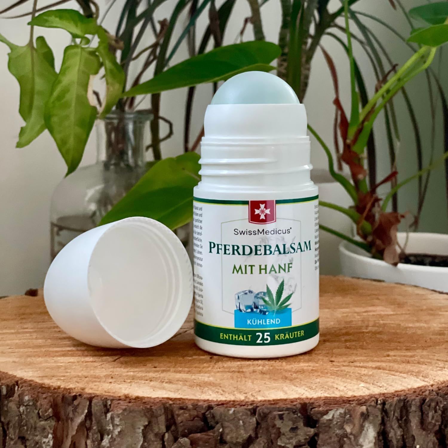 Roll-on-Flasche mit abgenommenem Deckel. Text: Pferdebalsam mit Hanf, kühlend, enthält 25 Kräuter. Logo: Schweizer Kreuz. Auf Holz.