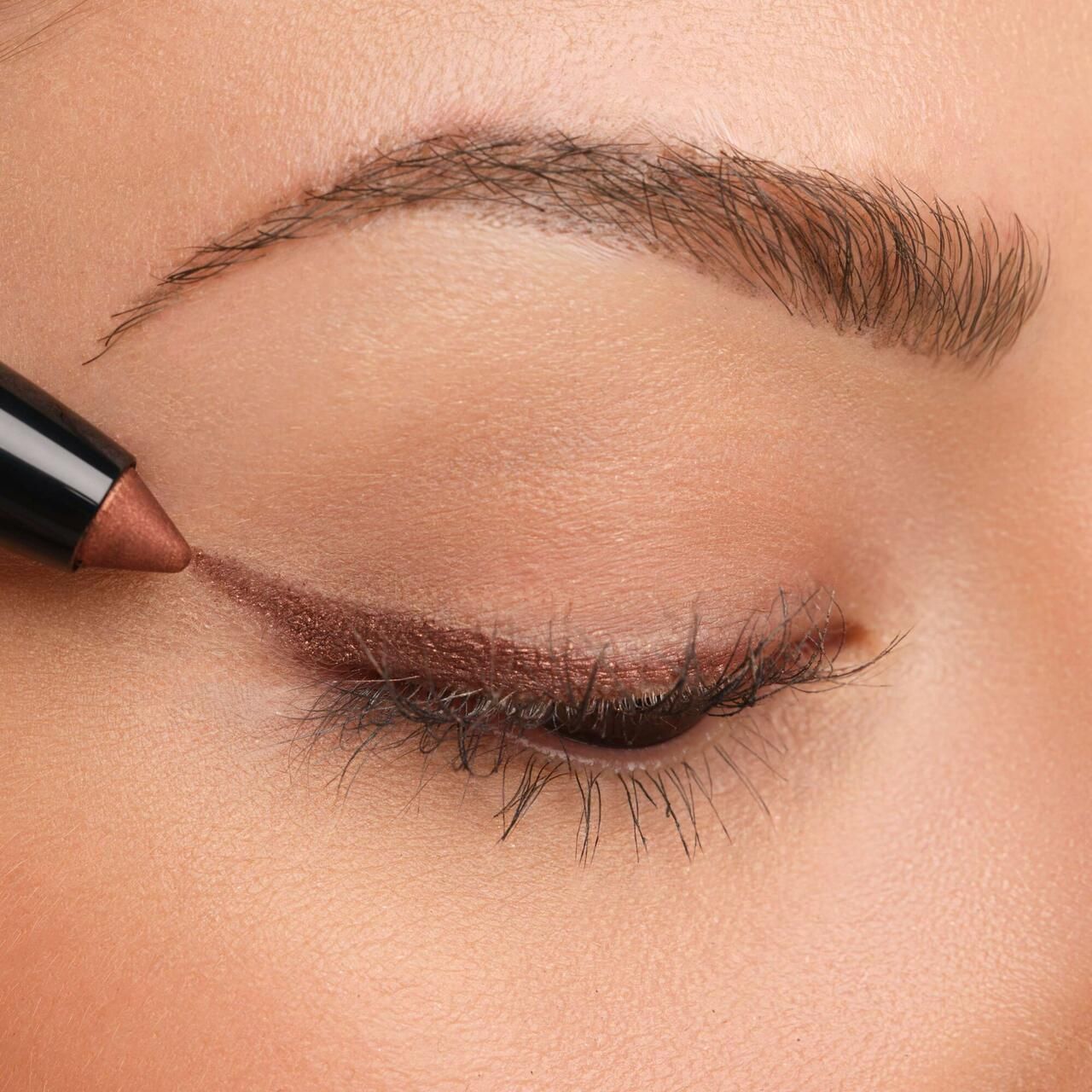 Auge mit aufgetragenem Artdeco High Performance Eyeshadow Stylo. Braune Lidschattenlinie am oberen Wimpernkranz.