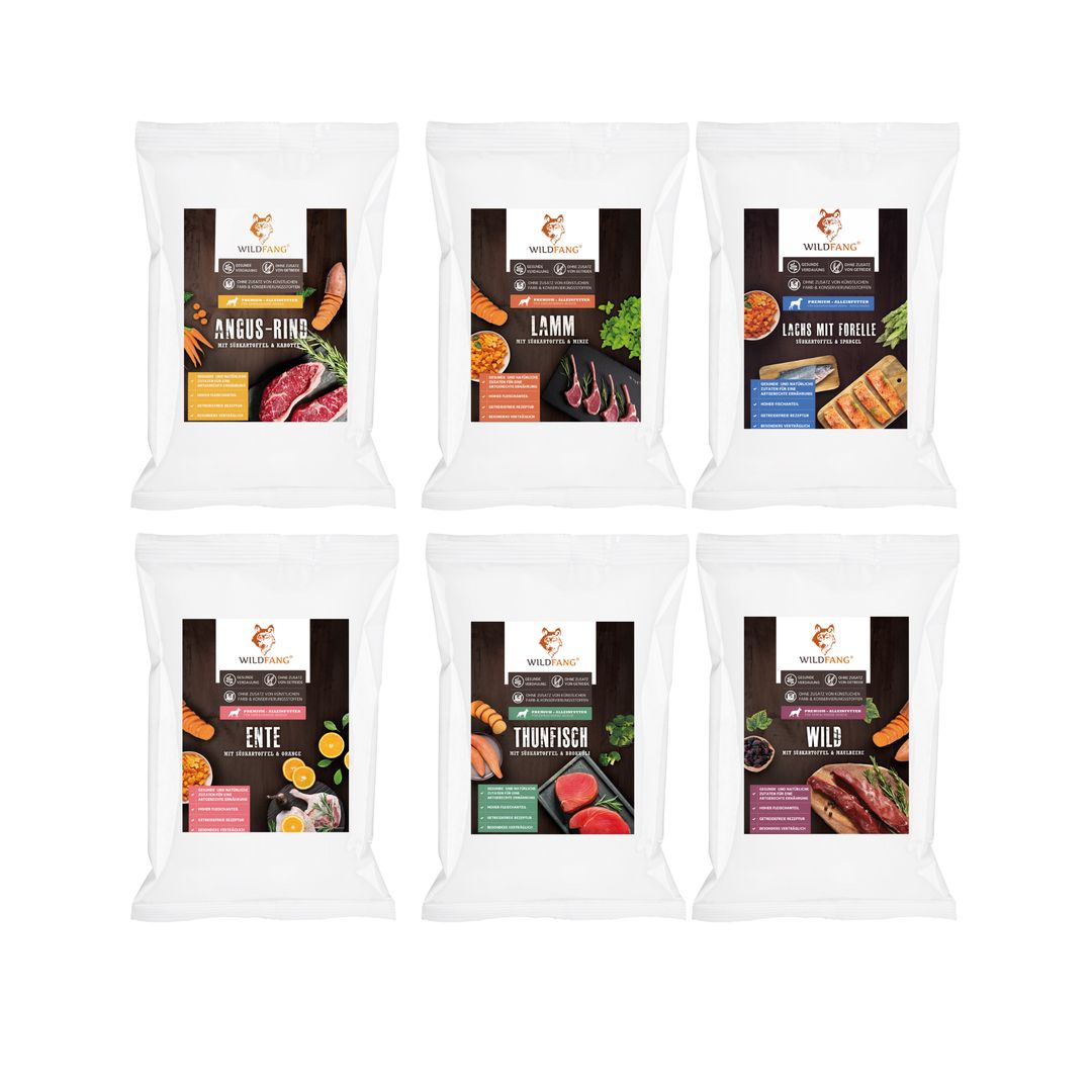 Sechs Beutel Trockenfutter, Wildfang. Aufdrucke: Angus-Rind, Lamm, Lachs mit Forelle, Ente, Thunfisch, Wild. Weiße Verpackung mit farbigen Grafiken.