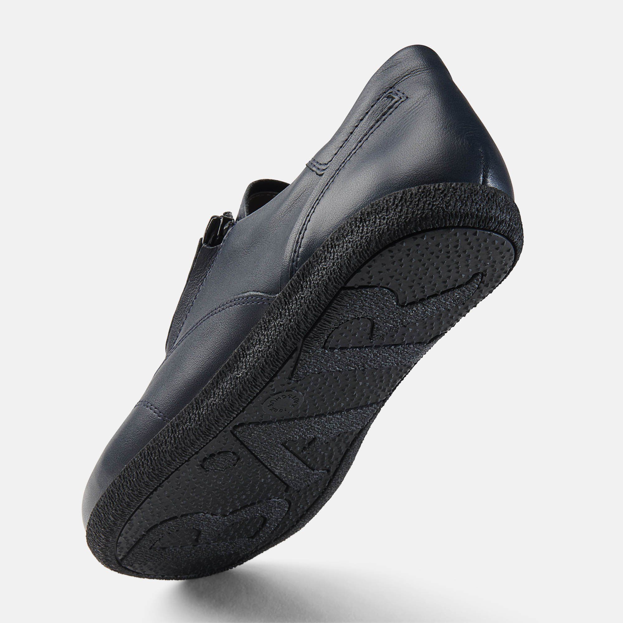 Blaue Ledersohle mit Profil. Schwarze Sohle. Schuh leicht schräg. Hellgrauer Hintergrund.