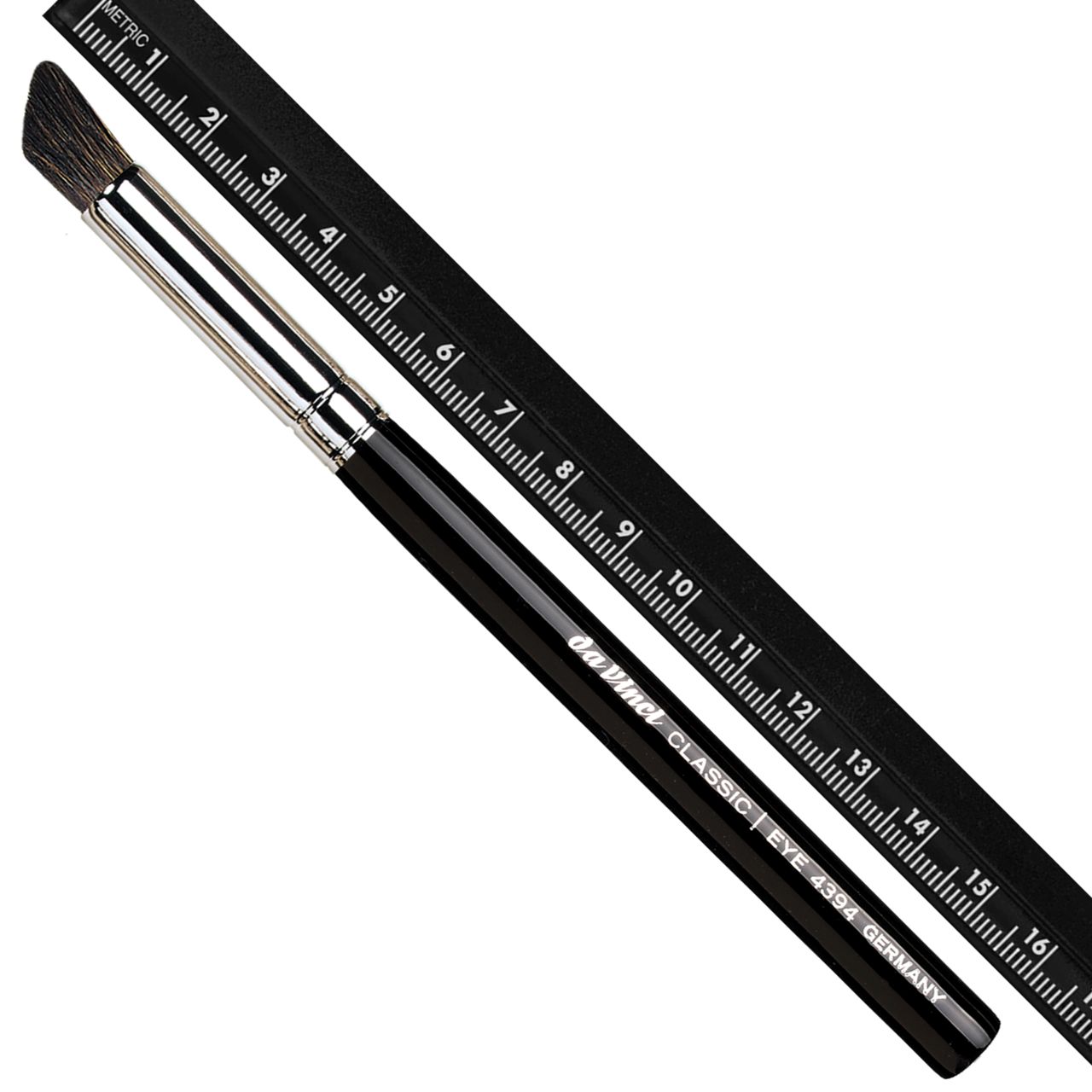 Pinsel mit schwarzem Griff, silberner Zwinge und schräg geschnittenen Borsten. Ein schwarzes Lineal liegt daneben. Aufschrift: Da Vinci CLASSIC EYE 4394 GERMANY.