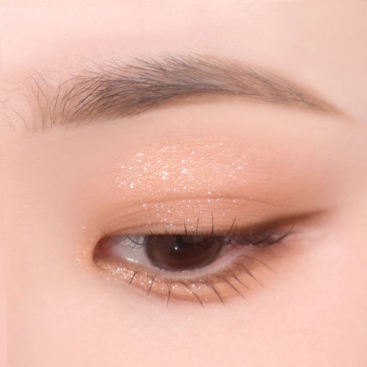 Auge mit Lidschatten. Goldener Glitzer auf dem Augenlid.