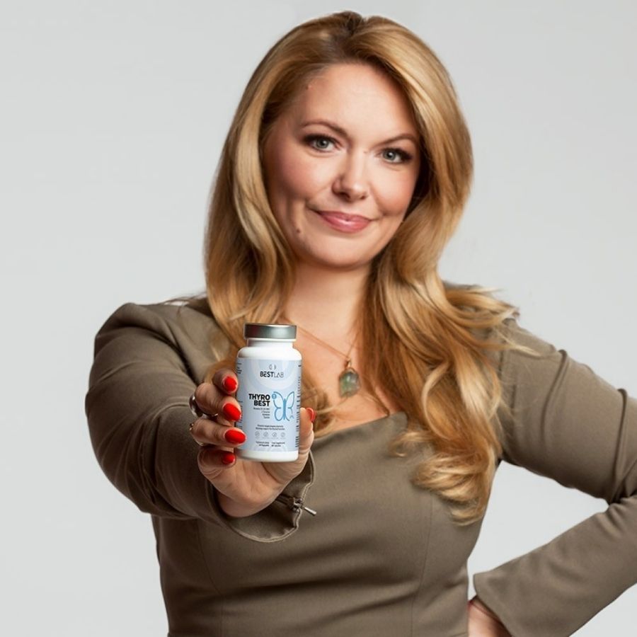 Eine Frau hält eine Flasche Thyro Best in die Kamera. Auf der Flasche ist das Best Lab Logo und Produktinformationen zu sehen.