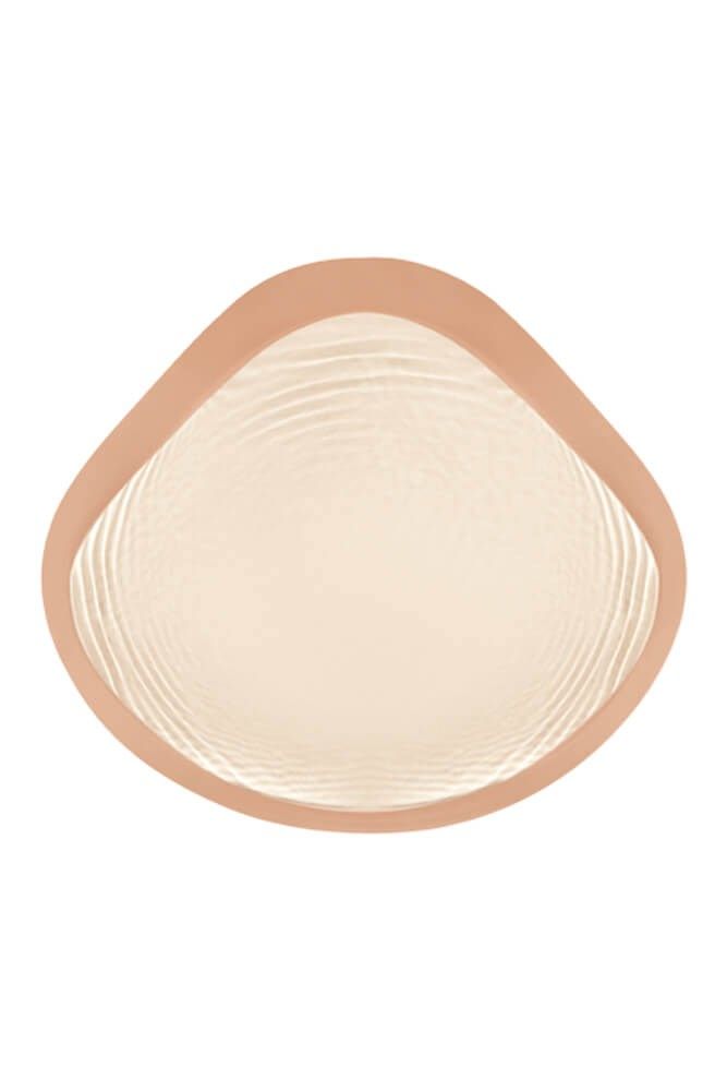 Brustprothese mit abgerundeter Form. Beige-farbener Rand, helle, strukturierte Innenfläche.