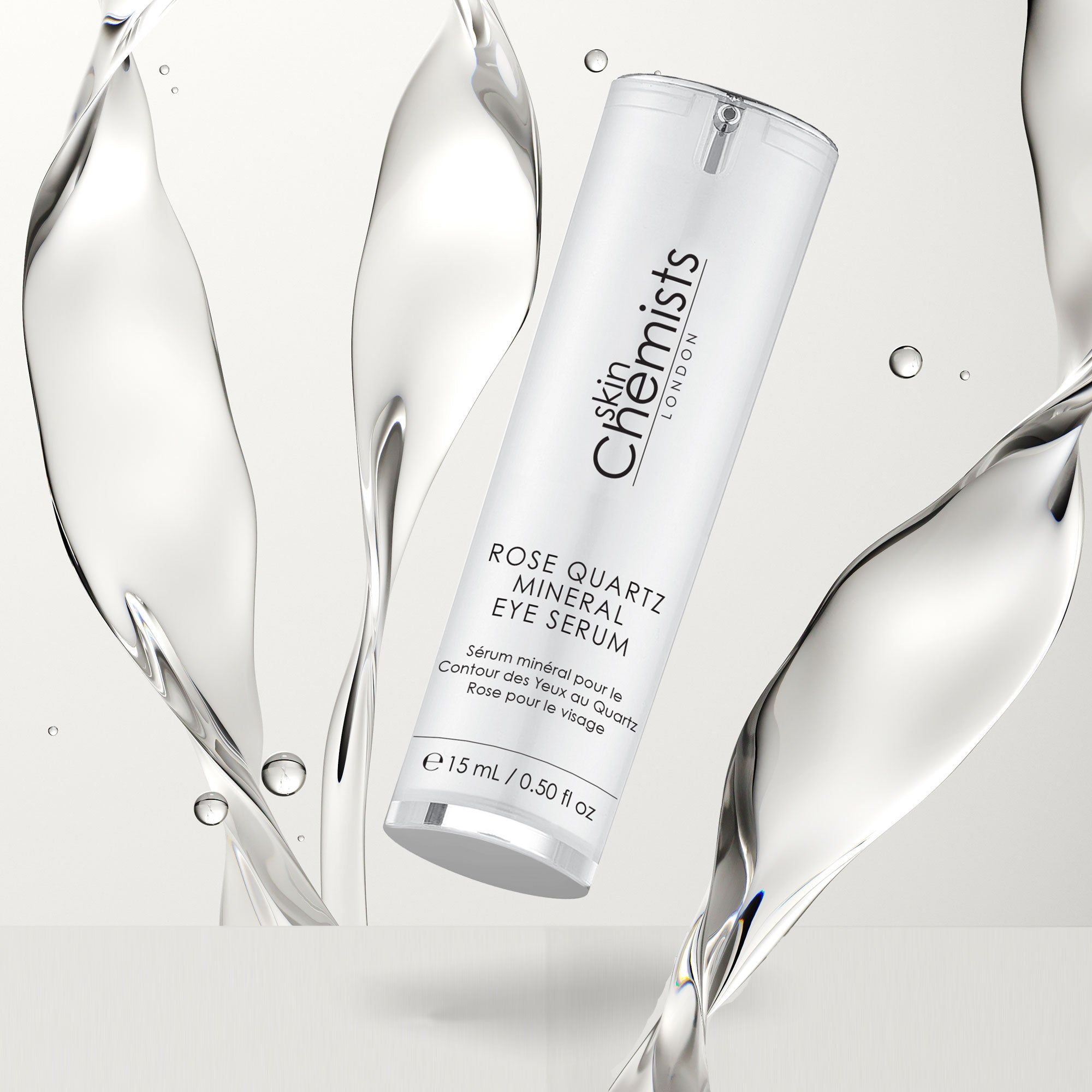 Frau hält Flasche. Aufschrift: Rose Quartz Mineral Eye Serum. Marke: skinChemists. Flasche mit Serum. Hintergrund: hellblau.