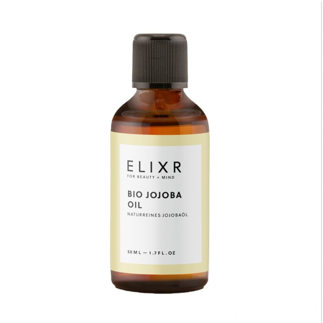 Braune Glasflasche mit schwarzem Deckel. Auf weißem Etikett steht "ELIXR BIO JOJOBA OIL".