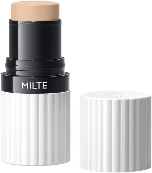 Foundation Stick MILTE, geöffnet. Beige Produktspitze, schwarzer Mittelteil mit MILTE-Schriftzug, weißer, geriffelter Behälter und Deckel.