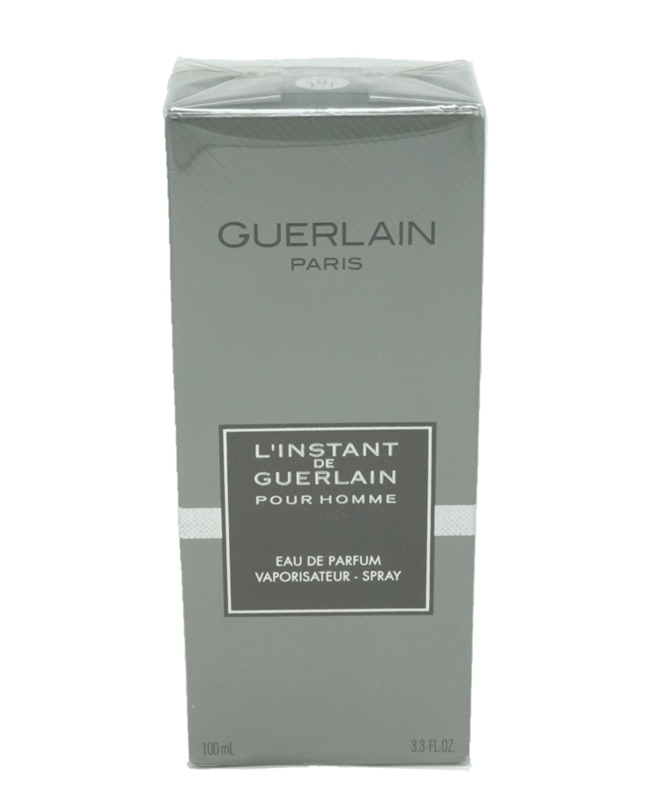 Graue rechteckige Verpackung. Oben steht GUERLAIN PARIS. Darunter ein rechteckiges Feld mit Text: L'INSTANT DE GUERLAIN POUR HOMME, Eau de Parfum, Vaporisateur-Spray.