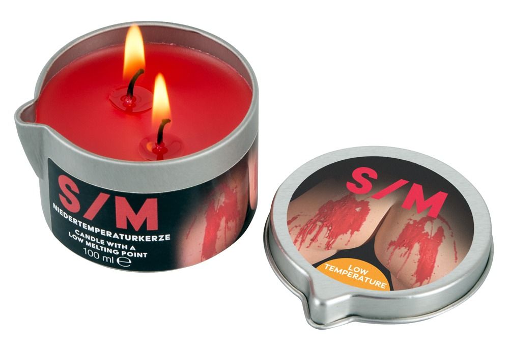 Rote Kerze in Metalldose mit zwei Flammen. "S/M Niedertemperaturkerze" und "100 ml" auf dem Etikett.