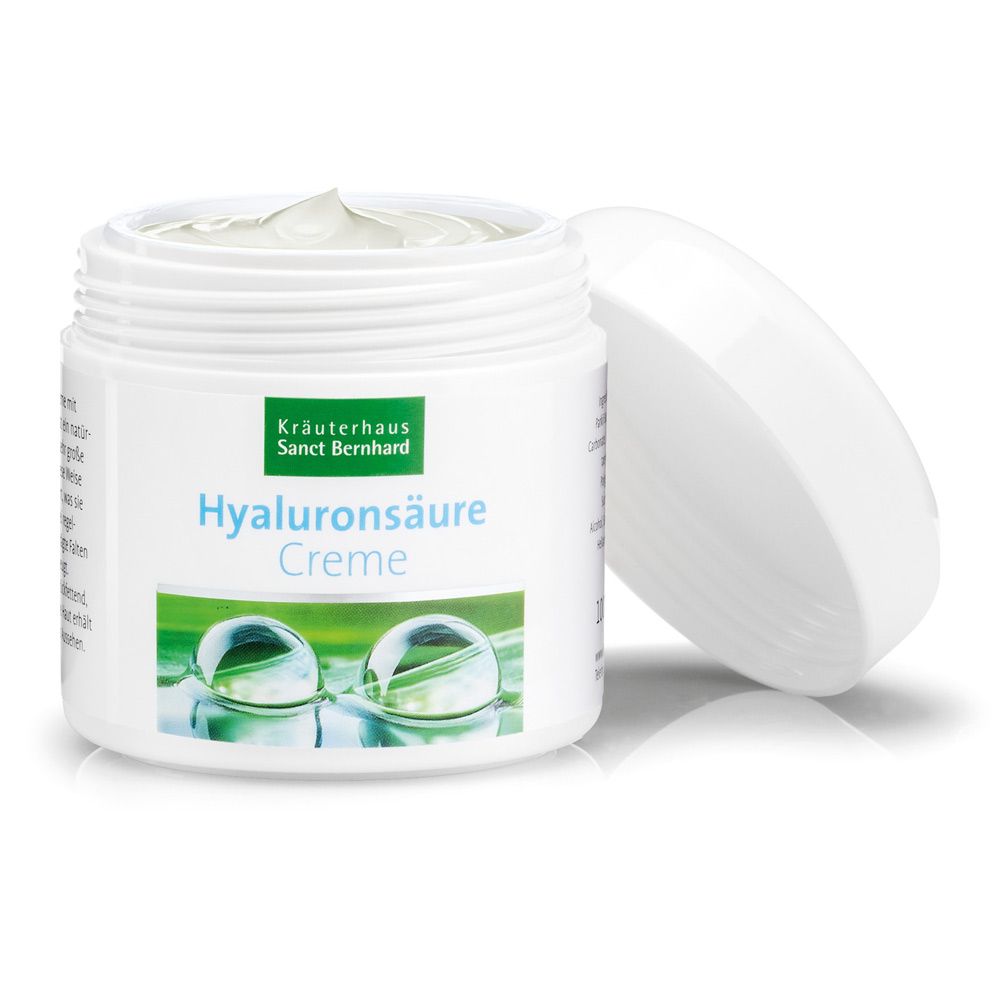 Offener weißer Tiegel mit Hyaluronsäure-Creme. Grüner Aufdruck, Schriftzug. Deckel daneben.