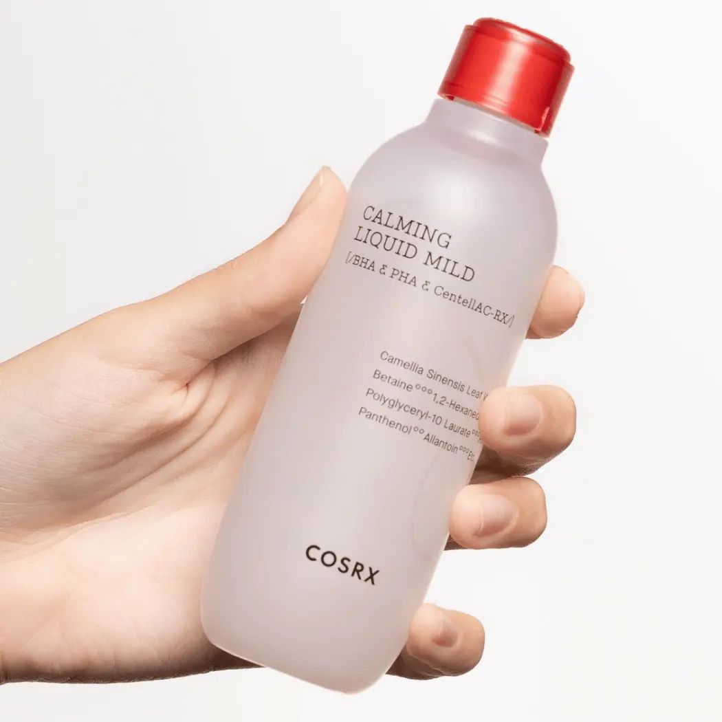 COSRX Calming Liquid Mild Flasche mit rotem Verschluss, gehalten von einer Hand.