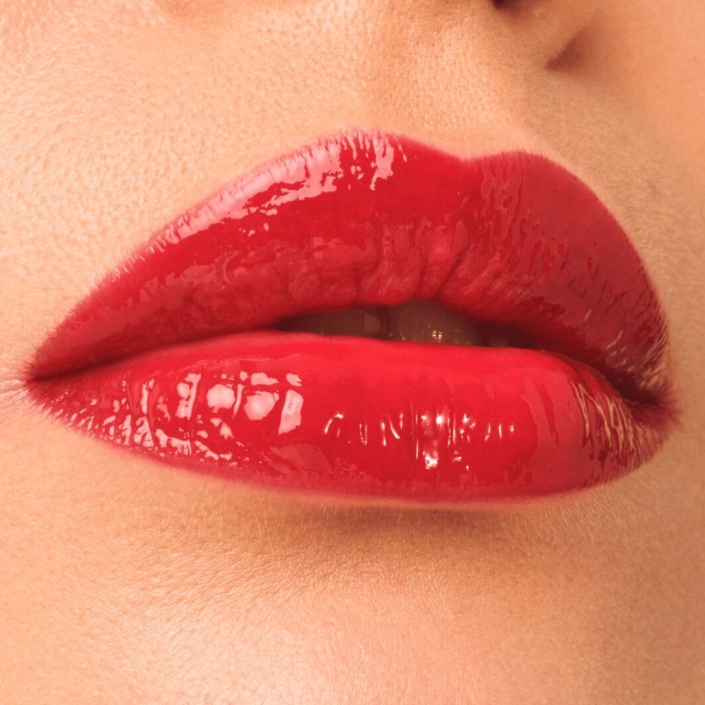 Nahaufnahme von roten, glänzenden Lippen. Produkt unbekannt.
