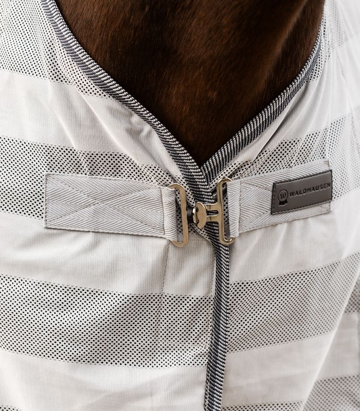 Detail der Pferdedecke mit Querstreifen. Helles Material, dunkle Ränder. Waldhausen-Logo.