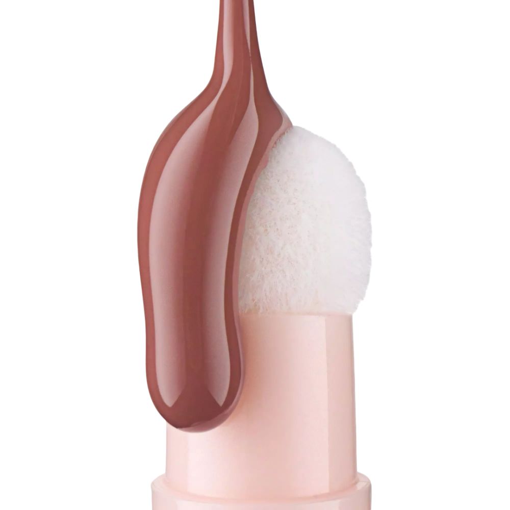 Nahaufnahme eines Applikators mit Lippenöl. Der Applikator hat eine runde, weiße Spitze. Das Öl ist braun.