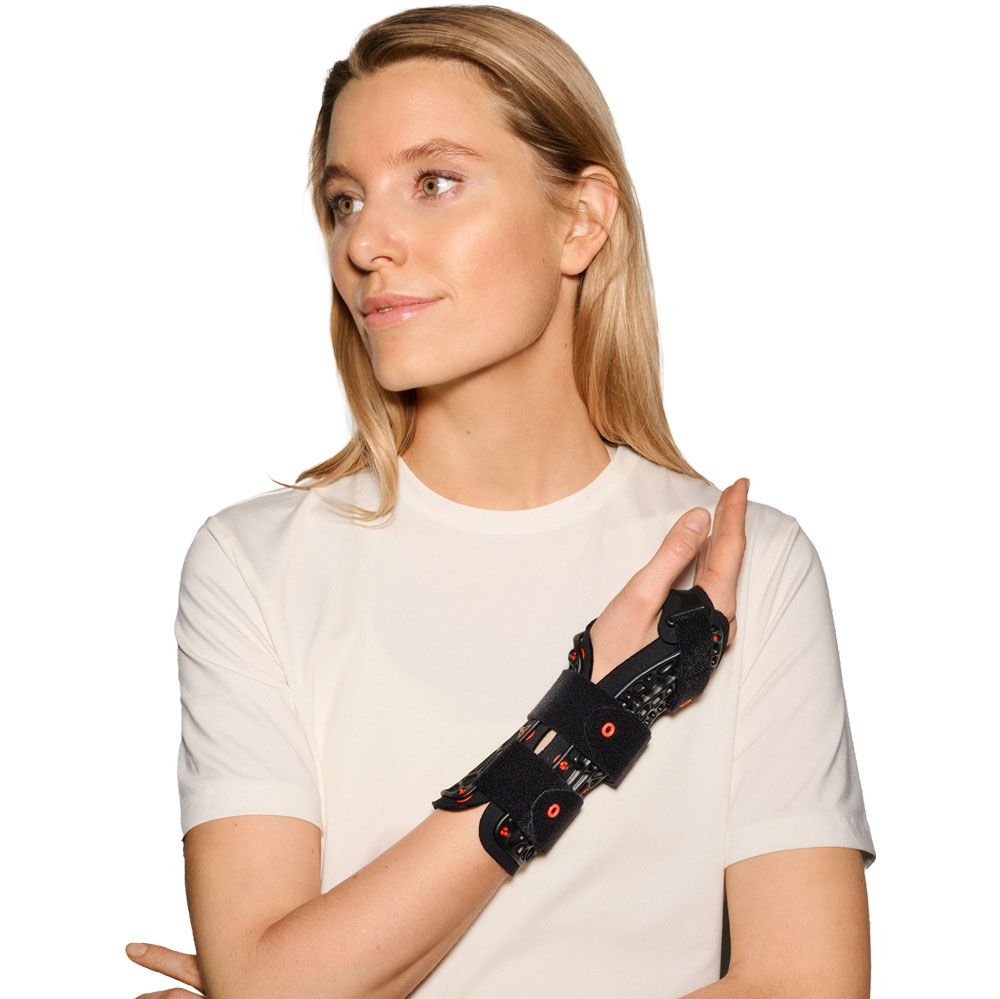 Frau trägt eine schwarze Handgelenkorthese am rechten Arm.