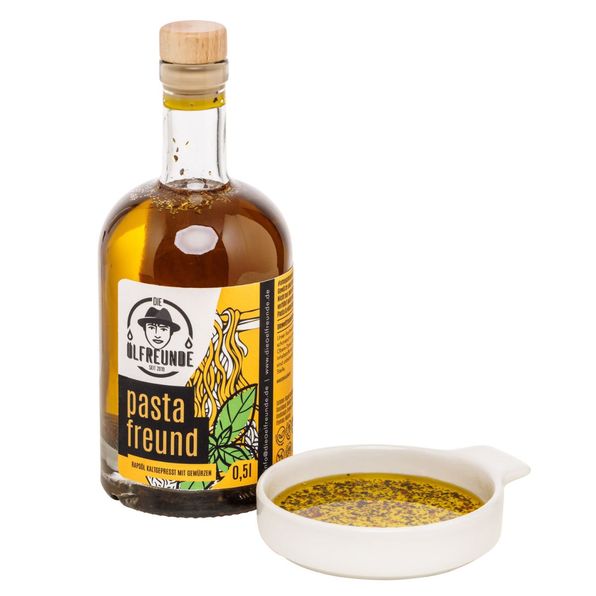 Glasflasche mit gelbem Inhalt und Aufkleber. Aufschrift: Ölfreunde, pasta freund, 0,5l. Mit Holzverschluss. Dazu eine Schale.