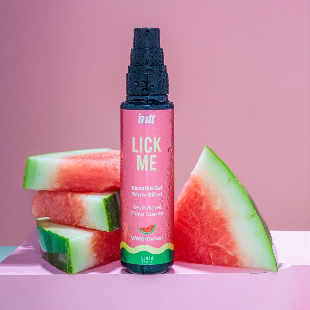 Rosa Flasche mit schwarzem Sprühkopf. Aufschrift "Lick Me" und "Watermelon". Wassermelonenstücke daneben.